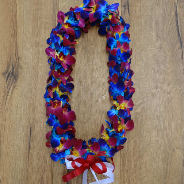 Colorful flower lei with red, blue, and yellow blossoms and a ribbon bow