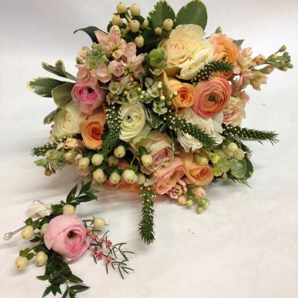 Pastel bouquet of roses and ranunculus with berries and greenery