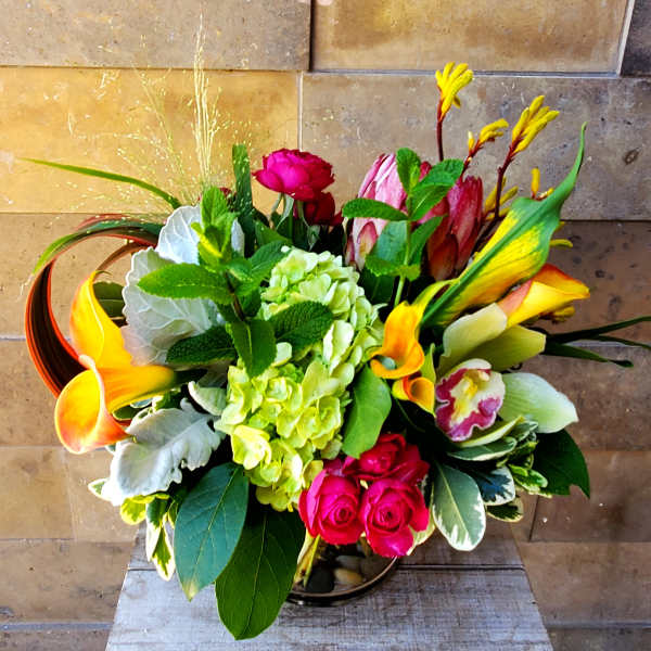 Colorful bouquet with roses, hydrangea, calla lilies, and orchids in a vase
