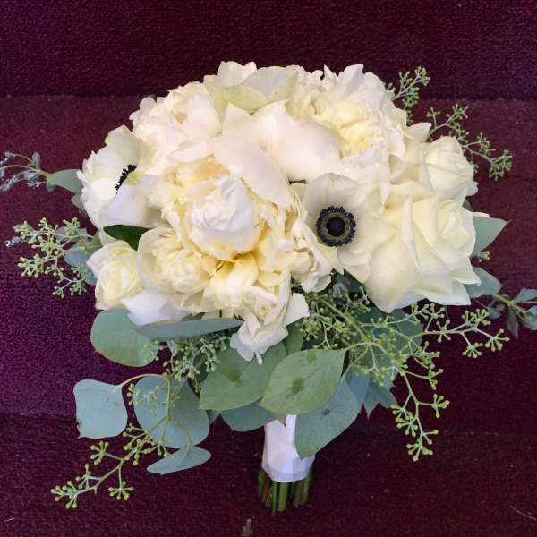 White bouquet with pale green foliage on a dark background