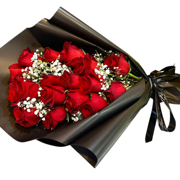 Bouquet of red roses wrapped in black paper with white baby's breath