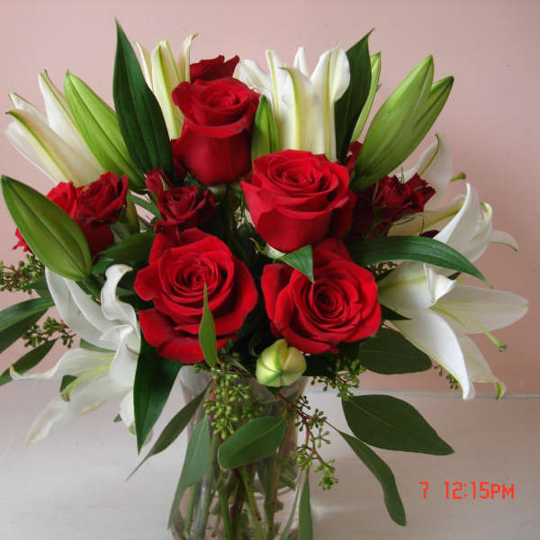 Bouquet of red roses and white lilies in a clear glass vase