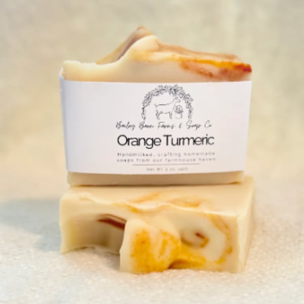 Two orange turmeric soap bars stacked on a soft surface