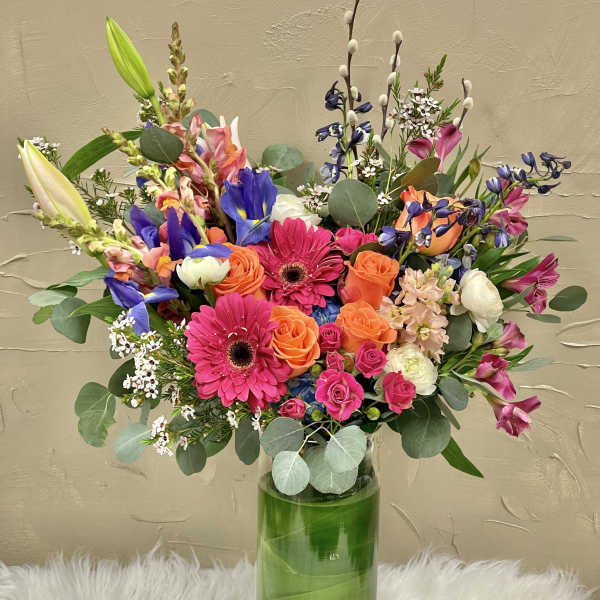 Colorful mixed bouquet in a tall glass vase