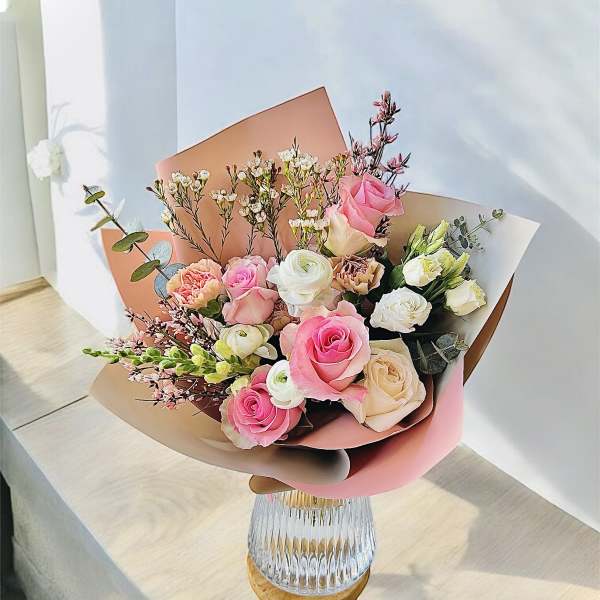 Bouquet of pink and white roses in a clear glass vase