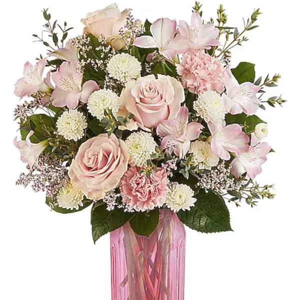 Pink roses and lilies arranged in a pink glass vase