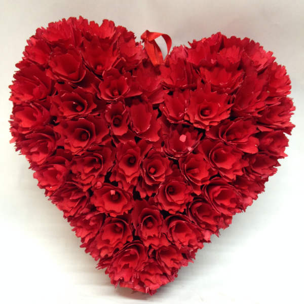 Heart-shaped arrangement of red carnations with a ribbon loop at the top