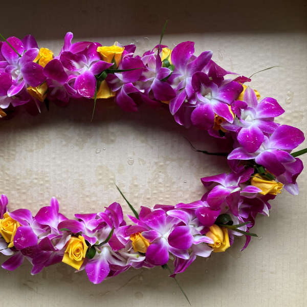 Oval floral lei with purple orchids and yellow roses
