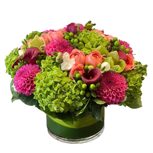 Bright mixed bouquet in a glass vase with pink, coral, and green blooms