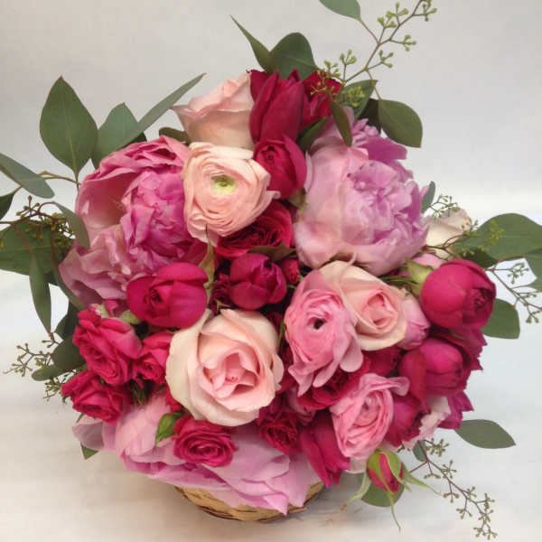 Pink and red rose bouquet in a woven basket