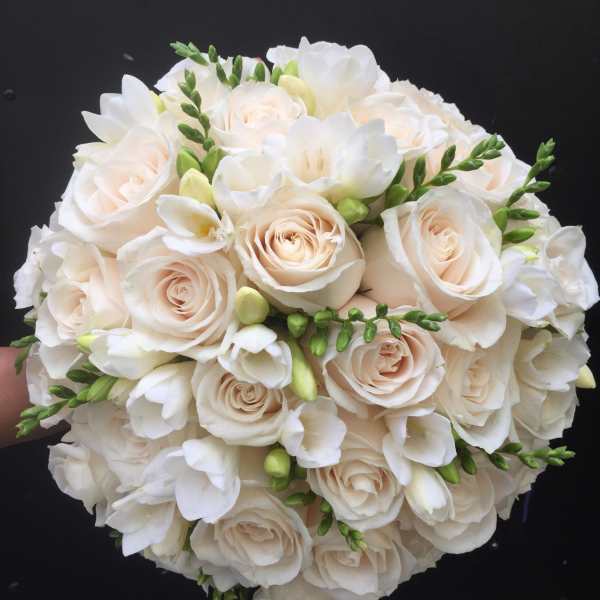 Round bouquet of white roses and white freesia with green buds