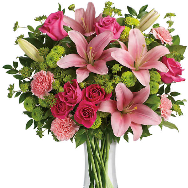 Pink lilies and roses arranged in a clear glass vase