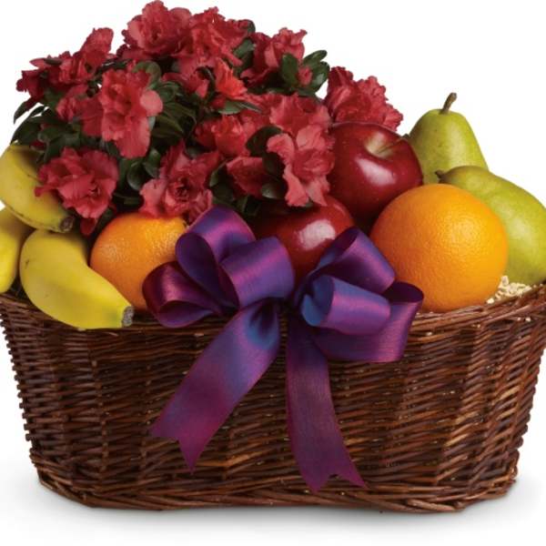 Fruit basket with red flowers and a purple ribbon