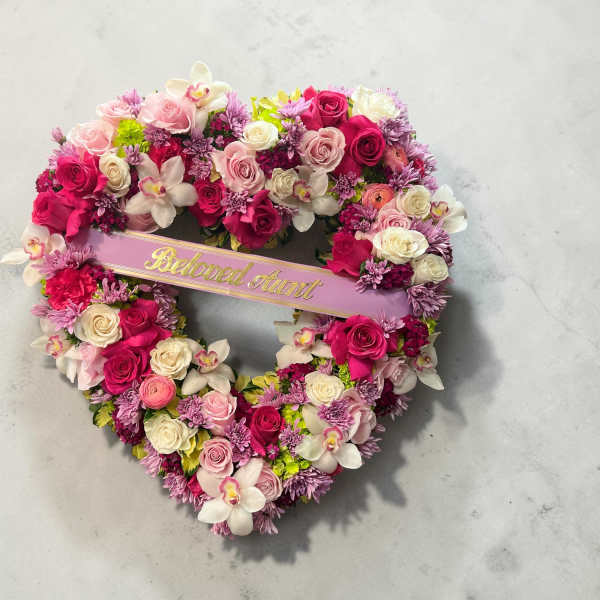 Heart-shaped floral wreath with pink and white roses and orchids