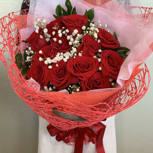 Bouquet of red roses with white baby's breath in red wrap