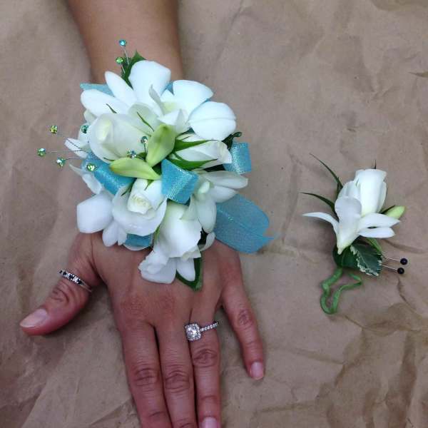 White floral wrist corsage and boutonniere with blue ribbon