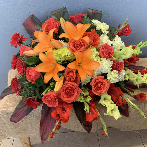 Bright bouquet of orange lilies, red roses, and red gerbera daisies