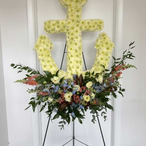 Anchor-shaped floral tribute on an easel with pastel flowers