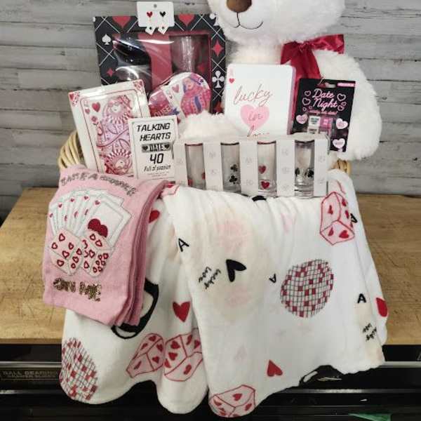 Gift basket with a teddy bear, cards, and heart-themed blankets