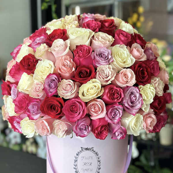 Large bouquet of multicolored roses in a pink hatbox