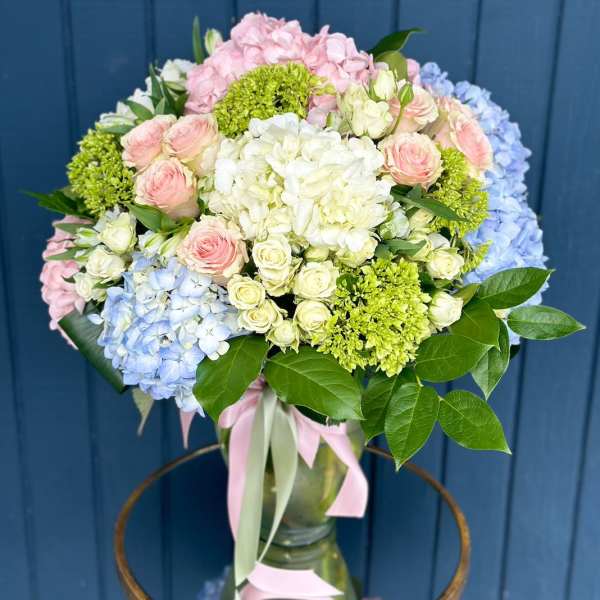 Pastel bouquet of hydrangeas and roses in a glass vase