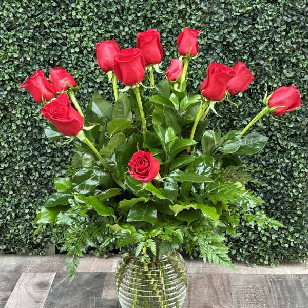 Red roses arranged in a clear glass vase