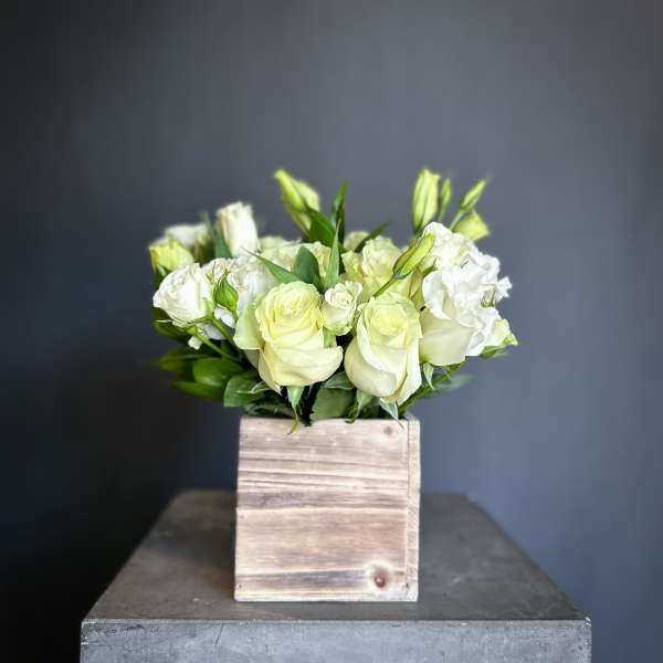 White roses and lisianthus in a wooden box
