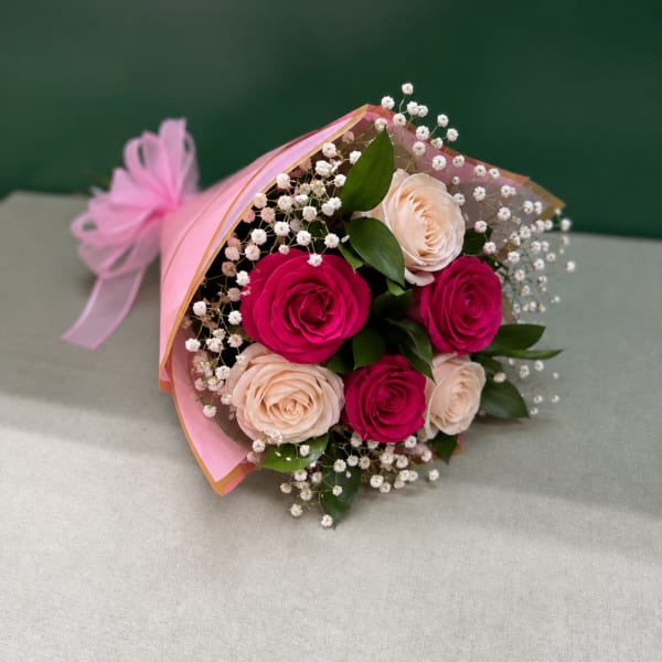 Bouquet of pink and blush roses with baby's breath wrapped in pink paper