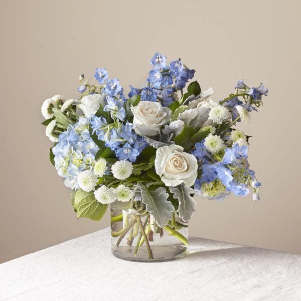 Blue and white flower bouquet in a clear glass vase