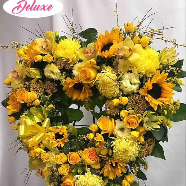 Heart-shaped yellow floral standing spray with sunflowers and roses