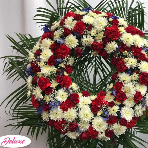 Large red, white, and blue floral wreath with palm fronds