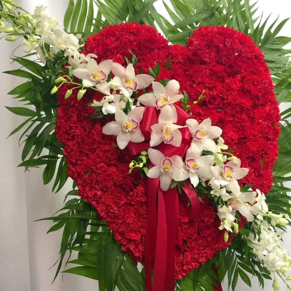 Heart-shaped red floral standing spray with white orchids and ribbon
