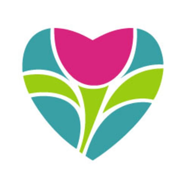 White roses and hydrangeas in a white wicker basket with a gold and burgundy ribbon bow