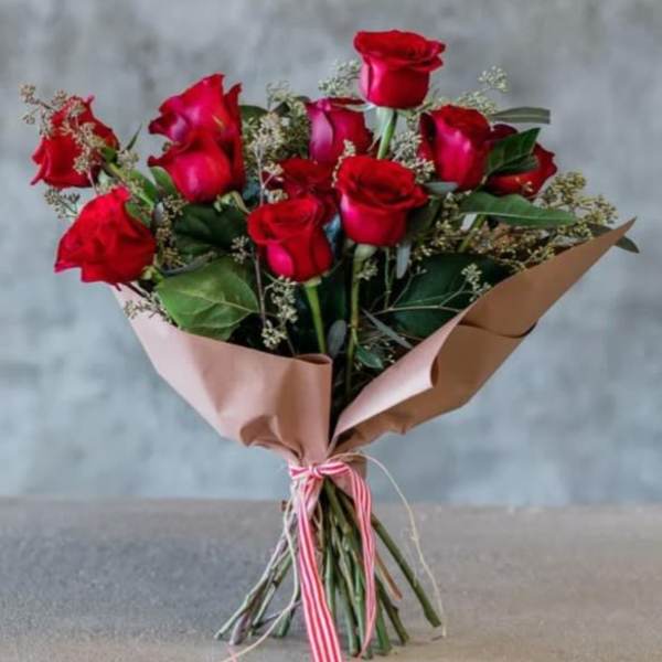 Bouquet of red roses wrapped in pink and brown paper