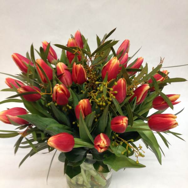 Bouquet of red and yellow tulips in a clear glass vase