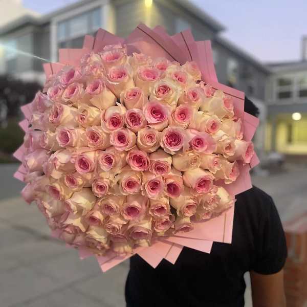 Large round bouquet of pale pink roses wrapped in layered pink paper