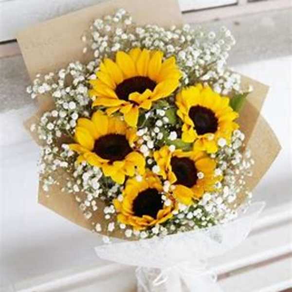 Bouquet of yellow sunflowers with white baby's breath in kraft paper