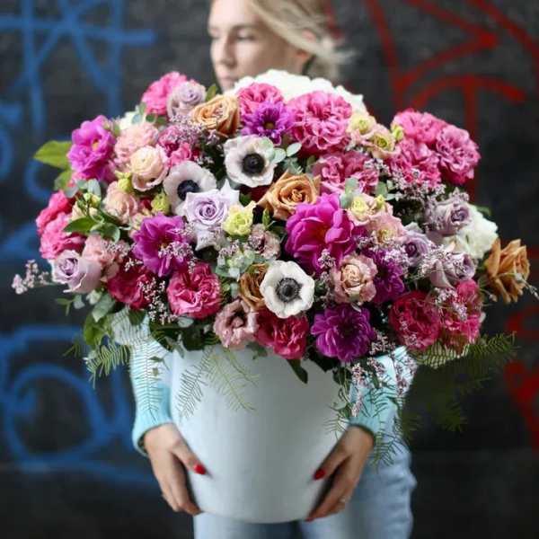 Large mixed bouquet in a white vase with pink, purple, and white blooms