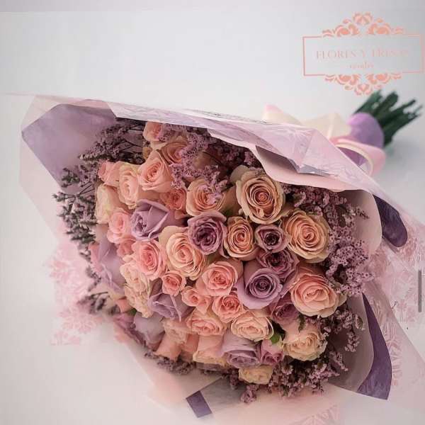 Bouquet of blush and lavender roses wrapped in pink paper