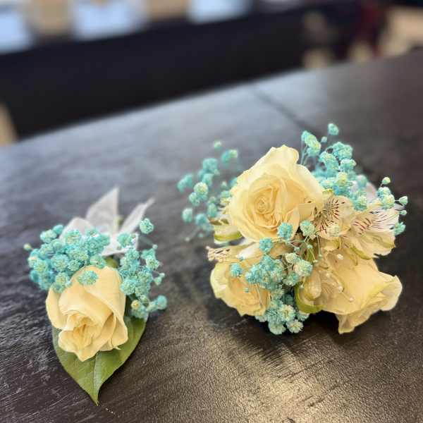 Two small floral arrangements with pale yellow roses and blue filler flowers