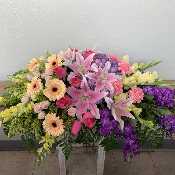 Large casket spray with pink lilies, gerbera daisies, and purple flowers