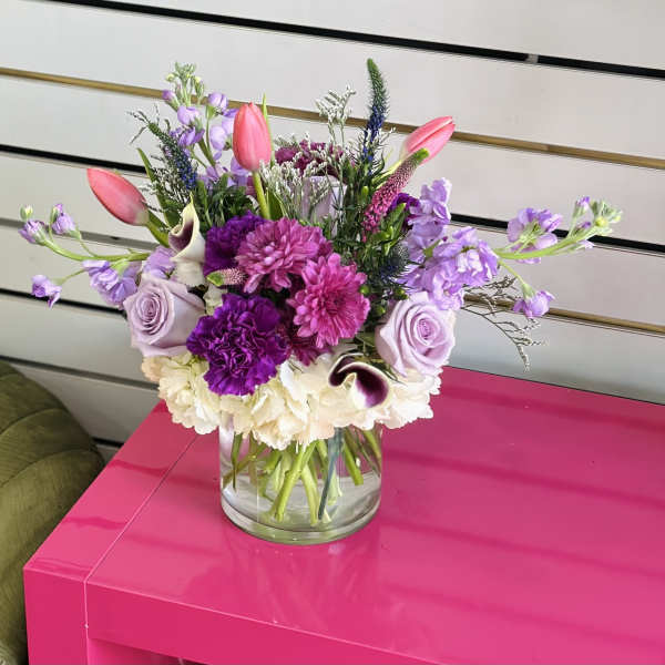 Mixed bouquet in a clear glass vase with pink, purple, and white flowers