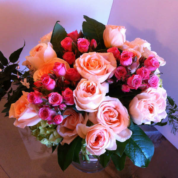 Bouquet of pink and peach roses in a clear glass vase