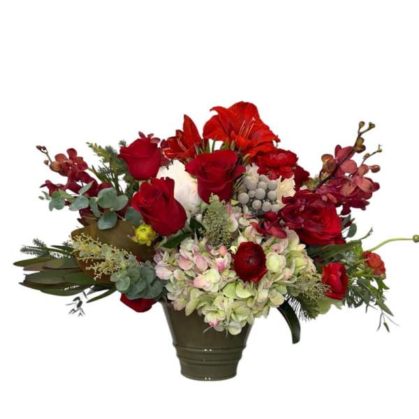Red roses and mixed flowers arranged in a dark vase