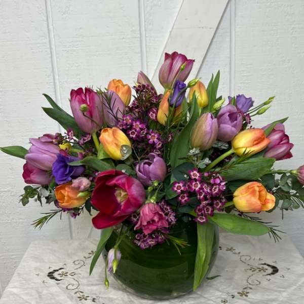 Colorful tulip bouquet in a green glass vase
