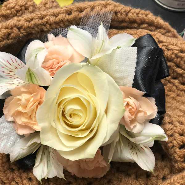 Cream rose and peach flowers arranged with black ribbon