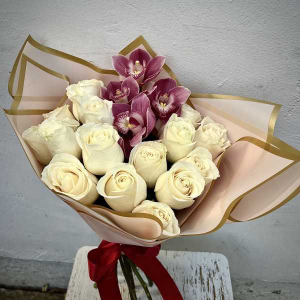 Bouquet of cream roses and pink orchids wrapped in blush paper
