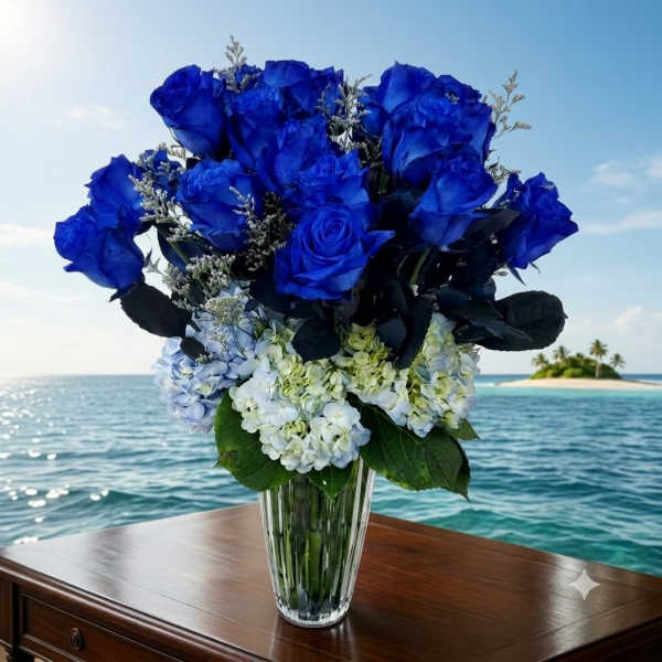 Blue roses and pale hydrangeas arranged in a clear glass vase