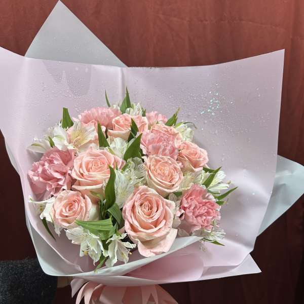 Pink rose and carnation bouquet wrapped in pale paper