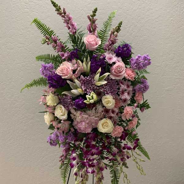 Tall floral spray with pink, purple, and white blooms on a stand